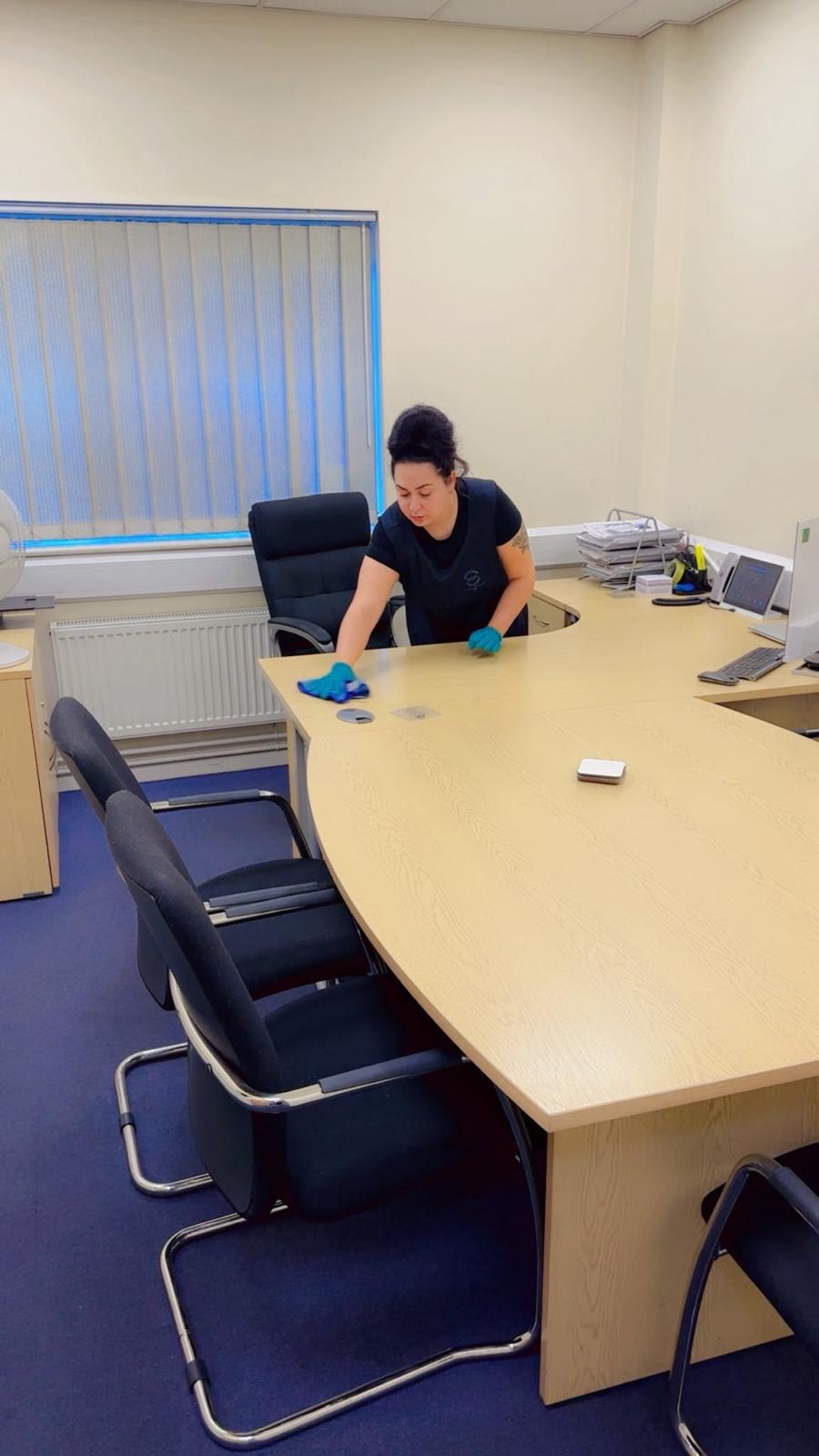 A Zeal FM operative cleaning desks at a customer office